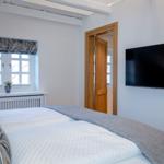 Bedroom with bed, window, and wall-mounted TV