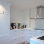White kitchen with stainless steel stove and countertop.