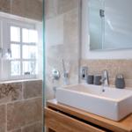 Bathroom with shower, sink, and window