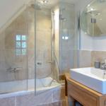Shower with glass enclosure, sink and mirror in a bathroom