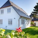 White villa with gray roof and green garden. House number 28 visible.