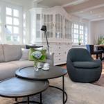 Living room with sofa, armchair, and dining table. Terracotta floor and white cabinet.