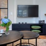 Living room with TV, coffee table, and floral arrangement.