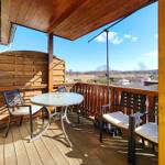 Sonniger Balkon mit Sitzmöbeln und weitem Blick über Loddin