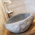 Stone sink on wooden base with modern faucet