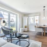 Living and dining area with wooden floor, windows, and modern furnishings.
