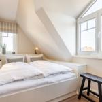 Room with double bed, windows, and TV