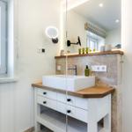 Bathroom with sink, mirror and window.