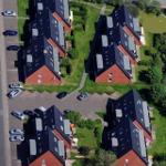 Luftbild von vier modernen Wohnhäusern mit Garten und Parkplatz.