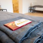 Ein Bett mit gefalteten Handtüchern und einer Schokoladentüte.