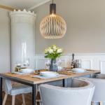 Esstisch mit Stühlen, Pendelleuchte und Blumenvase