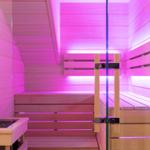 Sauna mit Holzbank und pinker Beleuchtung