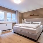 Schlafzimmer mit großem Bett und Blick auf Strand