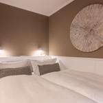 Schlafzimmer mit Bett, Kissen und Wanddekoration