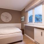 Schlafzimmer mit Bett, Fenster und Wanddekoration.