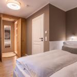 Schlafzimmer mit Bett, Kleiderschrank und Fenster