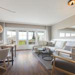 Wohn- und Essbereich mit Sofa, Tisch und Blick auf den Garten.