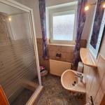 Badezimmer mit Dusche, Waschbecken und funktionaler Ausstattung.