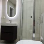 Badezimmer mit Dusche, Waschbecken und Spiegel