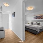 Schlafzimmer mit Bett und Wandbild. Flur mit Garderobe und Holzboden.