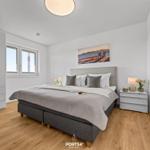 Schlafzimmer mit Bett, Nachttisch, Kleiderschrank und Fenster. Wandbild und Holzboden.