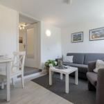 Wohn- und Essbereich mit Sofa, Tisch und Fenster