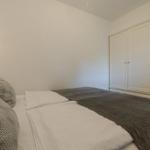 Schlafzimmer mit Bett, Kleiderschrank und Nachttischlampe.