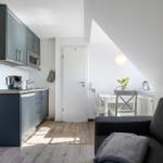 Küche mit Essbereich und Sofa unter Dachschrägen