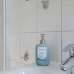 Waschbecken mit Seife und Dusche im Badezimmer