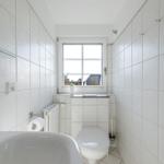 Badezimmer mit Toilette, Waschbecken und Fenster