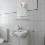 Badezimmer mit Dusche, Waschbecken und Toilette.
