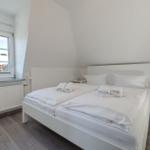 Schlafzimmer mit Doppelbett, Fenster und Nachttischen