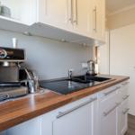 Küche mit Edelstahl-Kaffeemaschine, Holzoberfläche und Waschbecken.