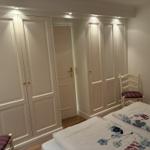Schlafzimmer mit Bett, Kleiderschränken und Stuhl.