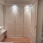 Schlafzimmer mit Kleiderschrank, Fenster und Holzboden. Treppe führt nach oben.