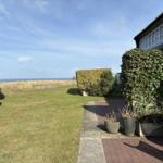 Garten mit Blick auf das Meer, Terrasse und grüne Pflanzen.