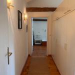 Flur mit Holzboden, Garderobe und Blick in Bad