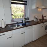 Küche mit Herd/Backofen, Kühlschrank, Spülmaschine, Kaffeemaschine, Toaster und Wasserkocher