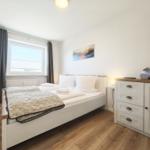 Schlafzimmer mit Bett, Schrank und Fenster