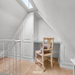 Dachgeschosszimmer mit Schreibtisch, Stuhl und Dachfenster.