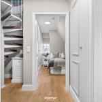 Schlafzimmer mit Bett und Fenster. Nebenher Wendeltreppe und Holzboden.