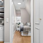 Schlafzimmer mit Dachschräge, Bett, Nachttisch und Fenster.