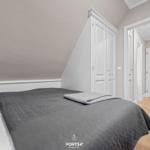 Schlafzimmer mit Dachschrägen, Bett und Kleiderschrank.