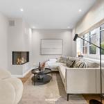 Wohnzimmer mit Sofa, Kamin und Tisch
