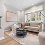Wohnzimmer mit Sofa, Kamin und Tisch