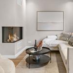 Wohnzimmer mit Ecksofa, Kamin und runden Tisch.