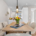 Essbereich mit Holztisch, Sitzbank und Blumenstrauß