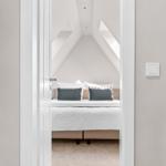 Schlafzimmer mit Dachschrägen, Bett und Fenster