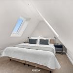 Schlafzimmer mit Dachschrägen, Dachfenster und Bett mit Kissen.
