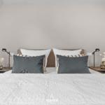 Schlafzimmer mit Bett, Nachttischen und Blumen.